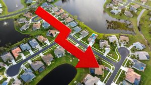 Aerial view of Florida neighborhood with a downward red arrow showing Florida Real Estate Market 2026 price trends