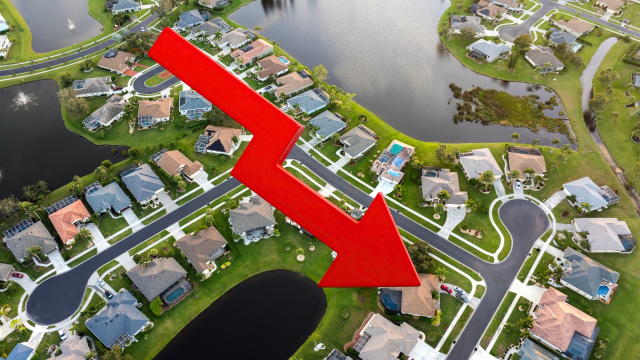 Aerial view of Florida neighborhood with a downward red arrow showing Florida Real Estate Market 2026 price trends