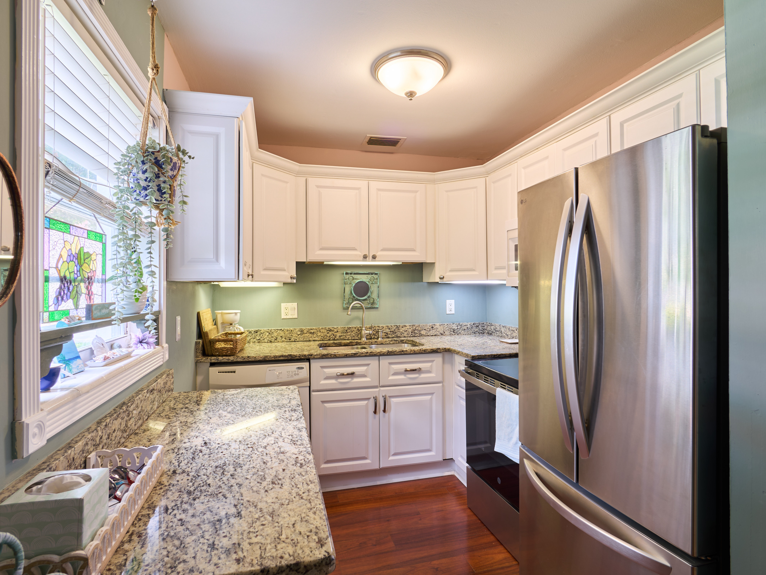 Updated kitchen with granite countertops and white cabinets in Vista Pines condo in Stuart, Florida